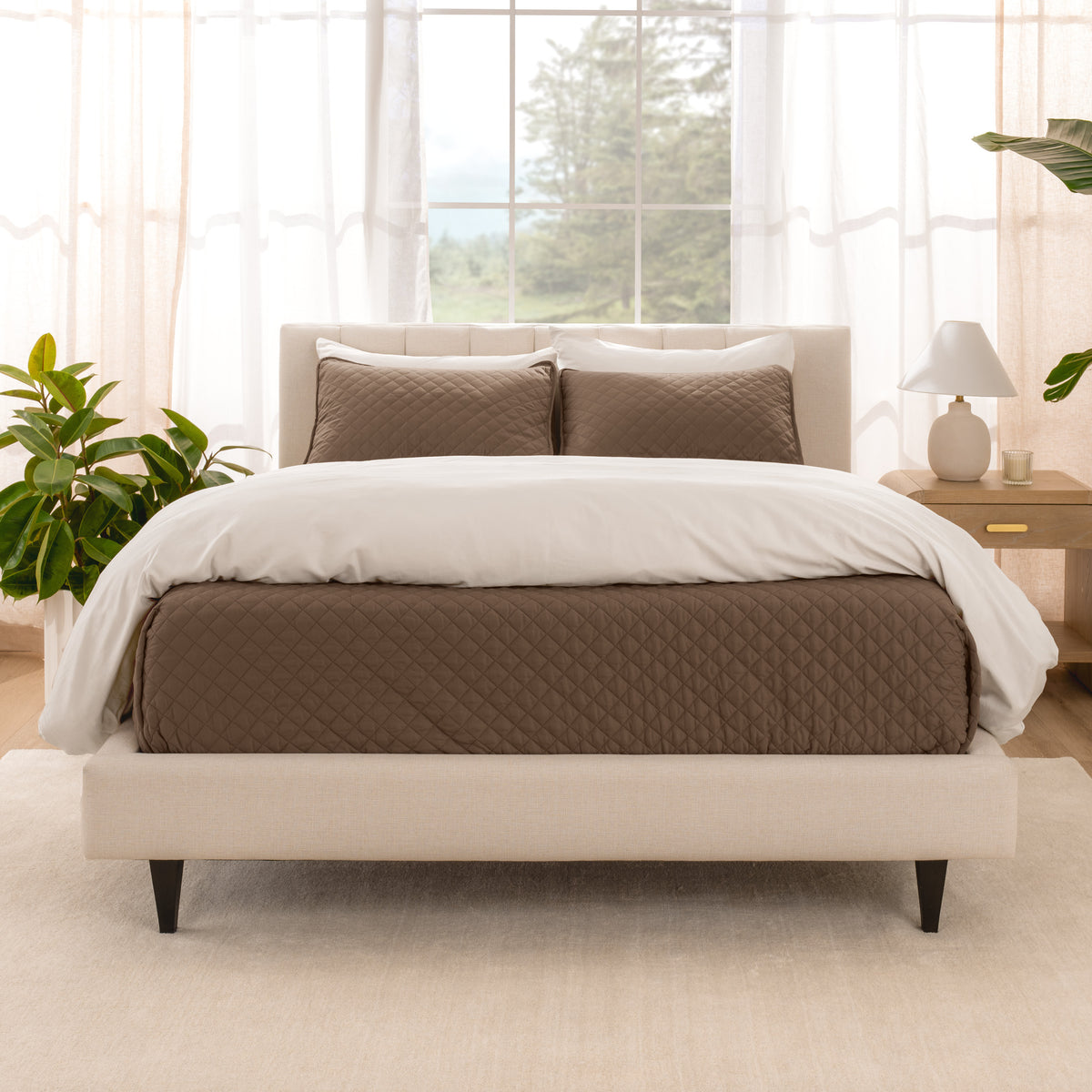 A bright bedroom with a coverlet set on the bed