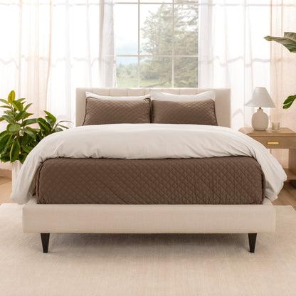 A bright bedroom with a coverlet set on the bed