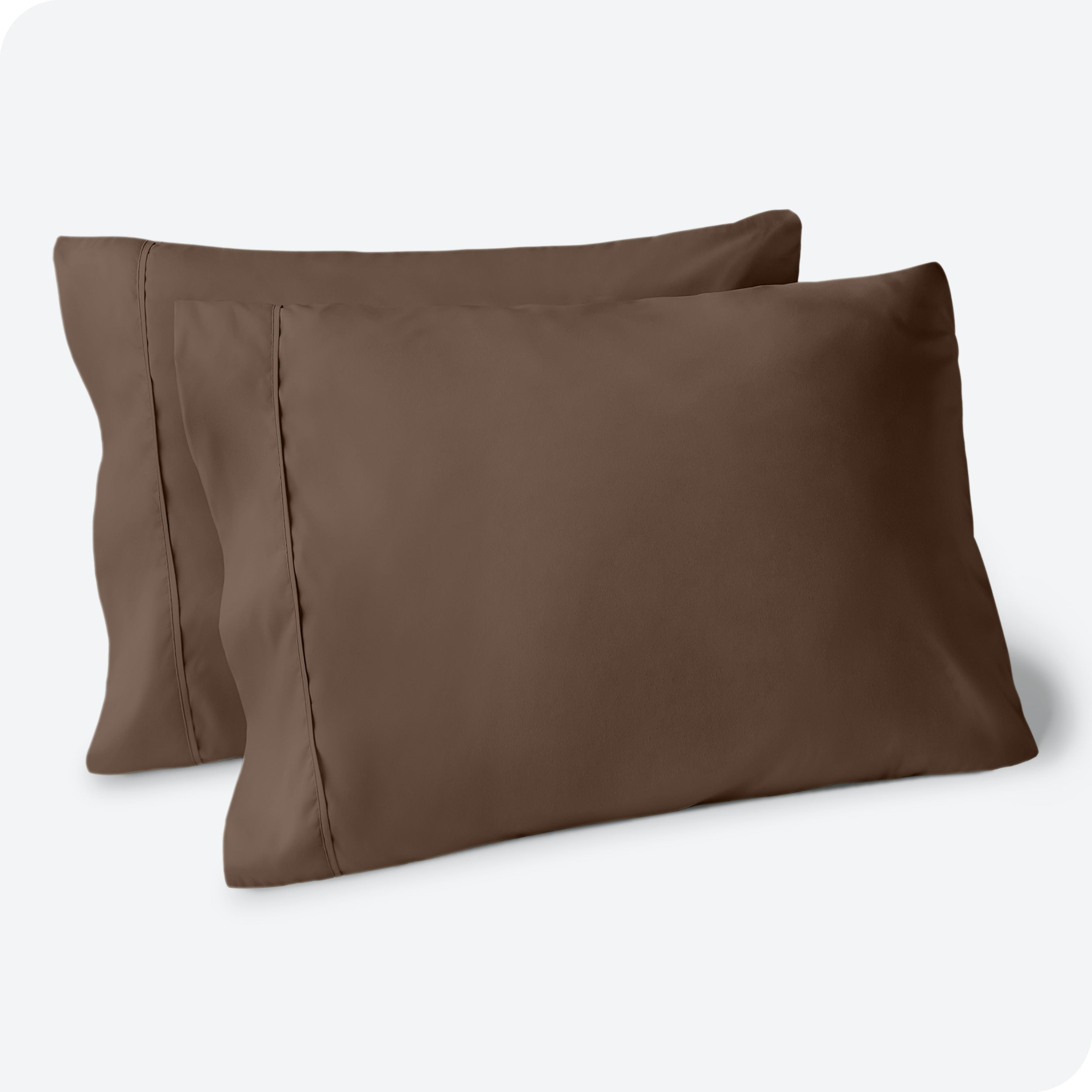 Two pillows on a white background with cocoa pillowcases on them