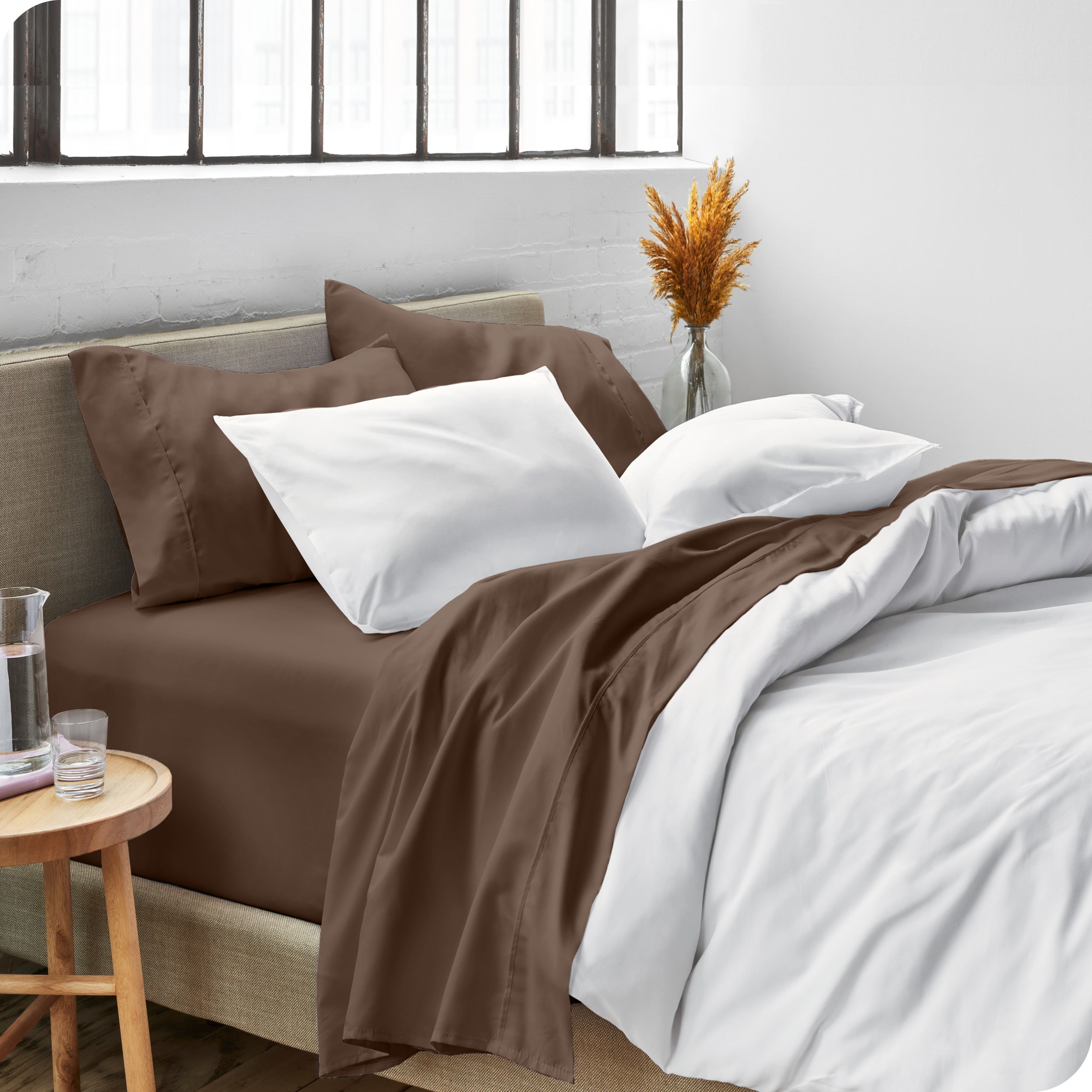 Sheets and a duvet cover on a bed in a bright bedroom
