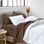 A side view of a bed made with microfiber sheets and a white duvet cover