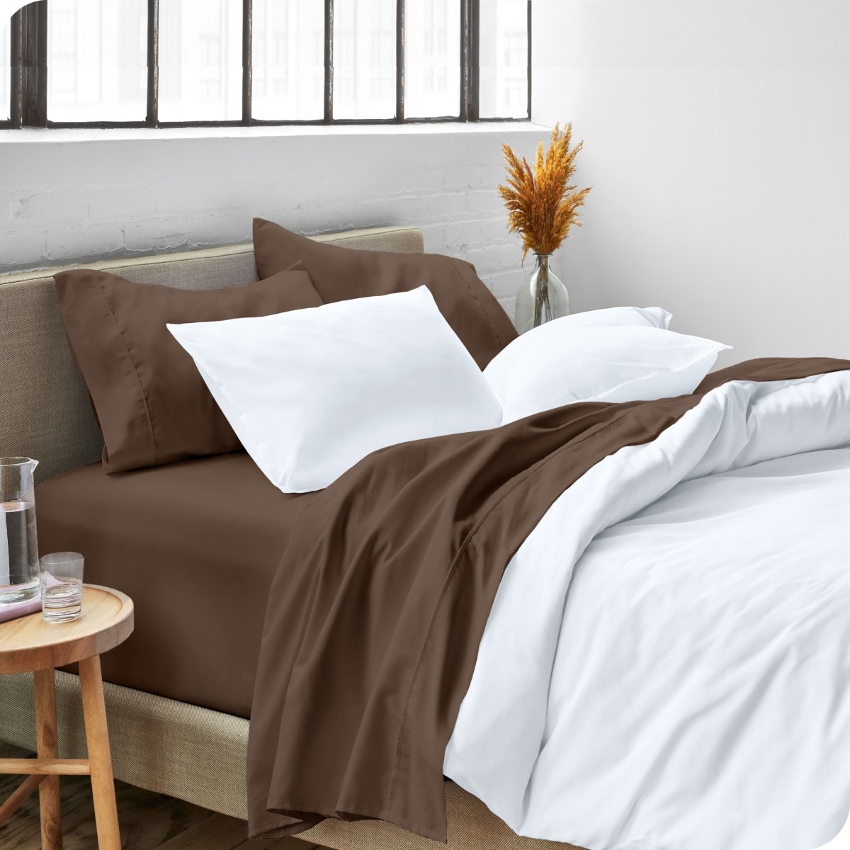 A side view of a bed made with microfiber sheets and a white duvet cover