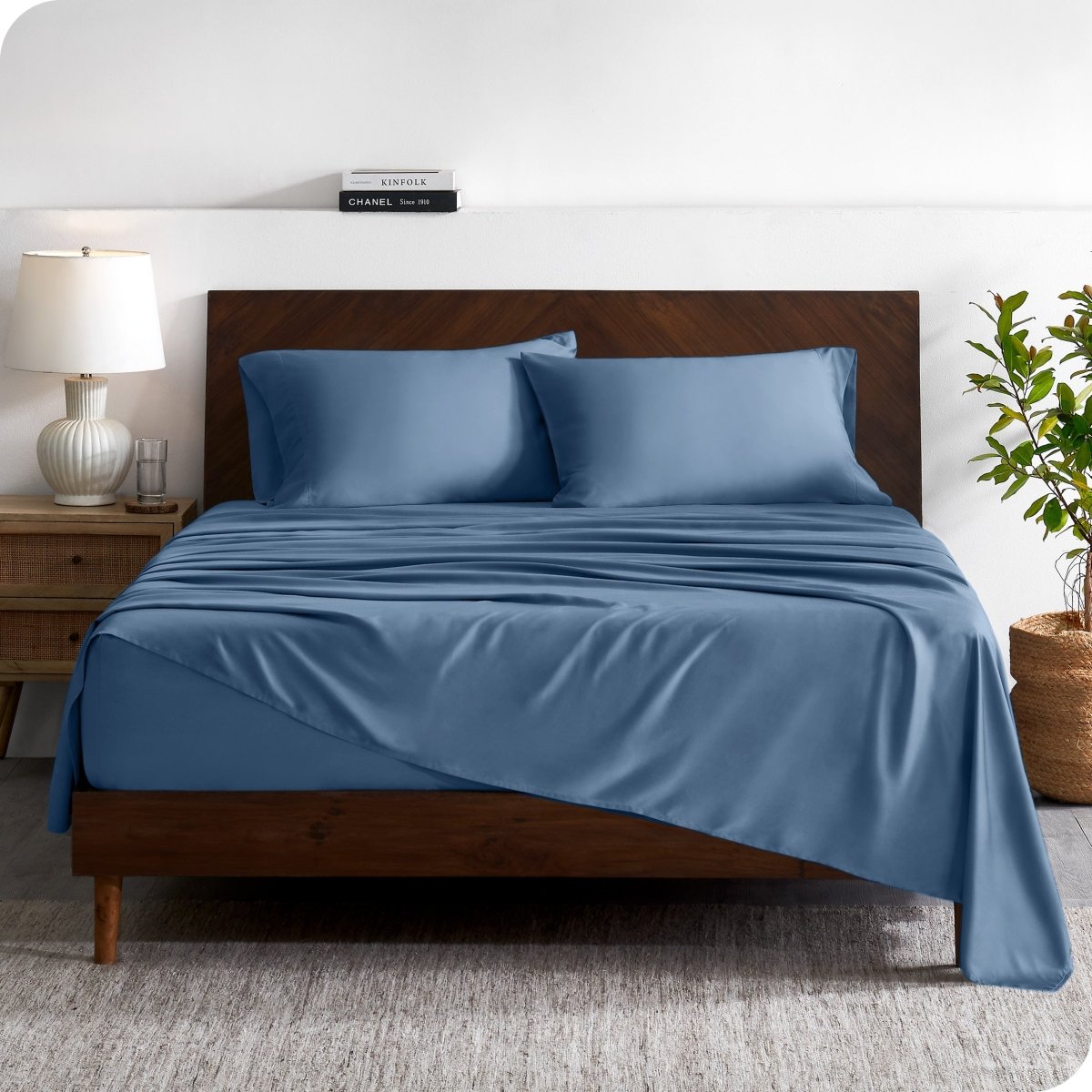 A contemporary bed with a sheet set and a wooden headboard.