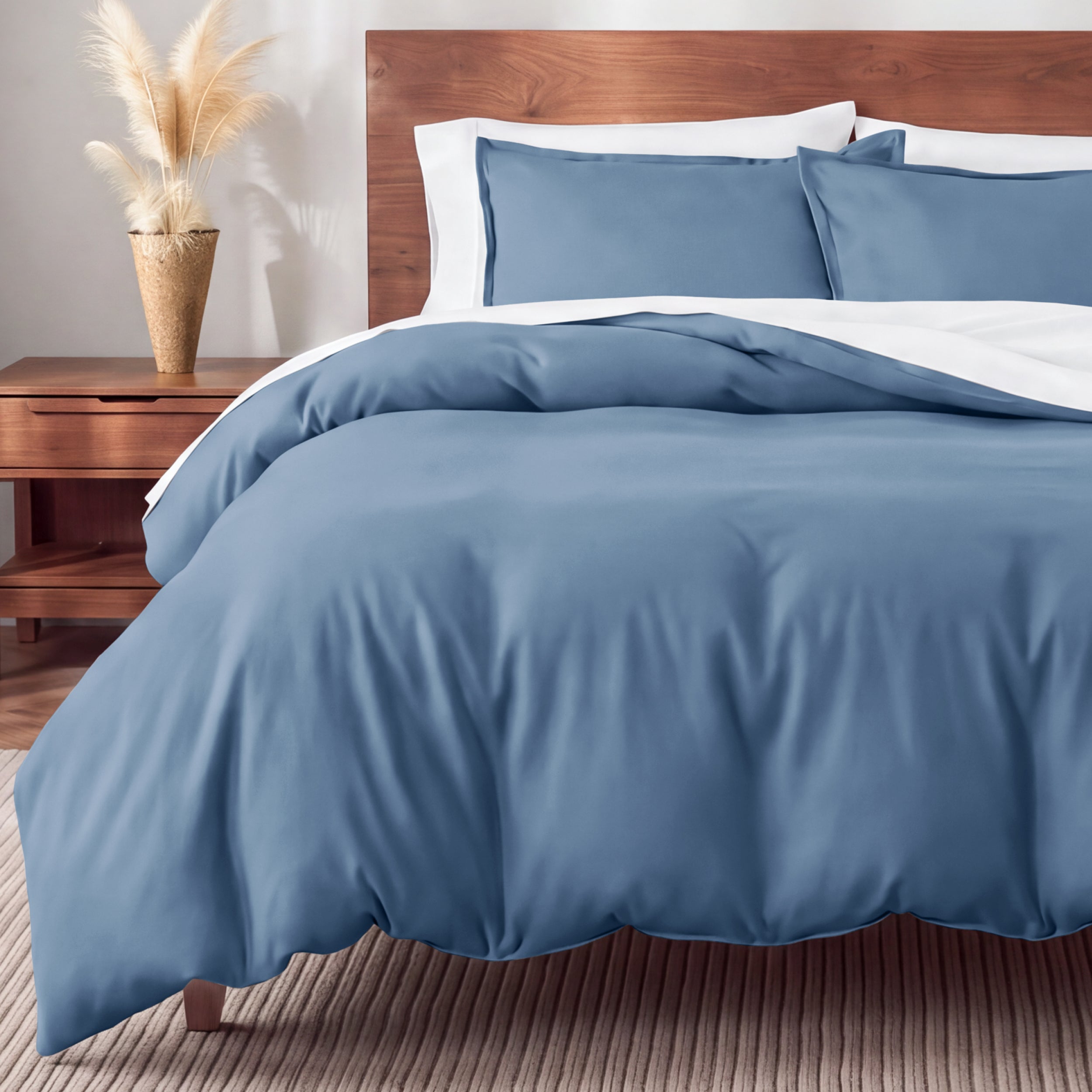 Flannel bedding set on a bed in a bedroom with a nightstand and lamp.