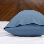 Body pillowcase with an envelope closure on a bed with a wooden headboard