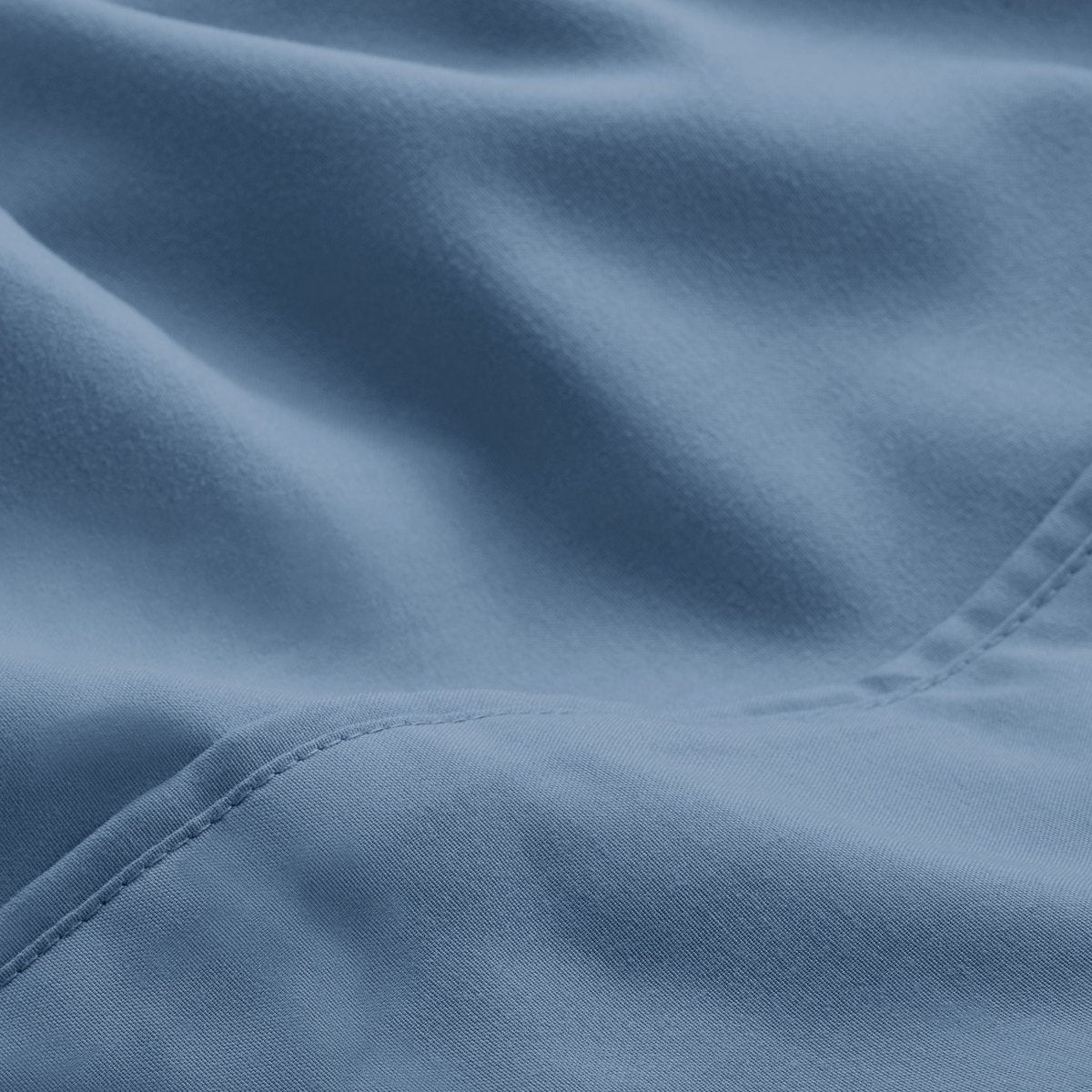 A close-up of microfiber fabric with soft folds and a visible stitched seam.