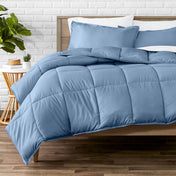 Comforter set on a bed with a white brick wall and plant in the background