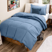 Bed with comforter and pillows in a dorm room