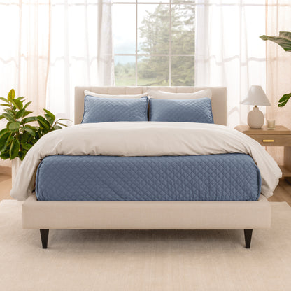 A bright bedroom with a coverlet set on the bed