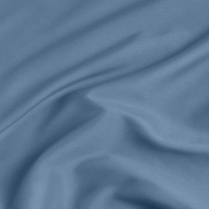 A close-up of a fitted sheet with a label printed with the word 'BOTTOM' in white.