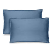 Two blue pillow shams on pillows standing up with one behind the other