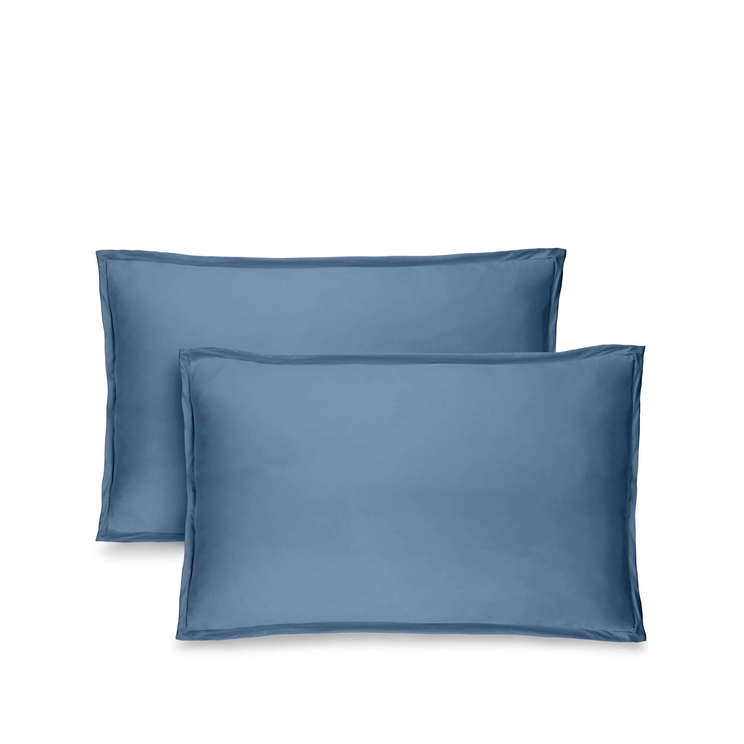 Two blue pillow shams on pillows standing up with one behind the other