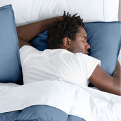 Man sleeping with his head resting on a pillow sham