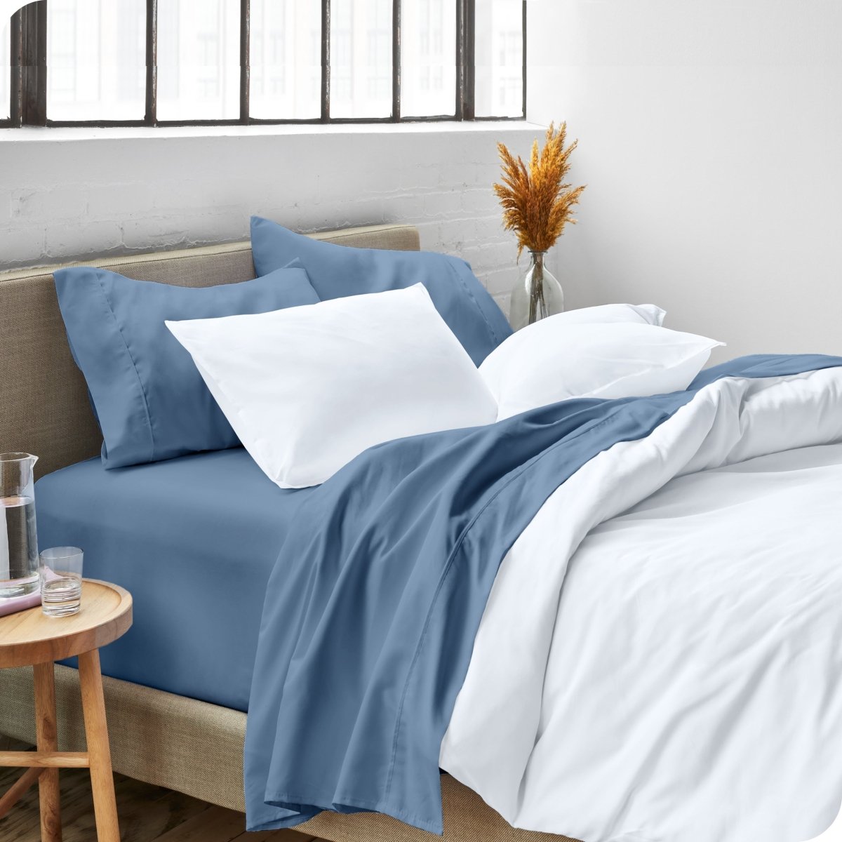 A side view of a bed made with microfiber sheets and a white duvet cover