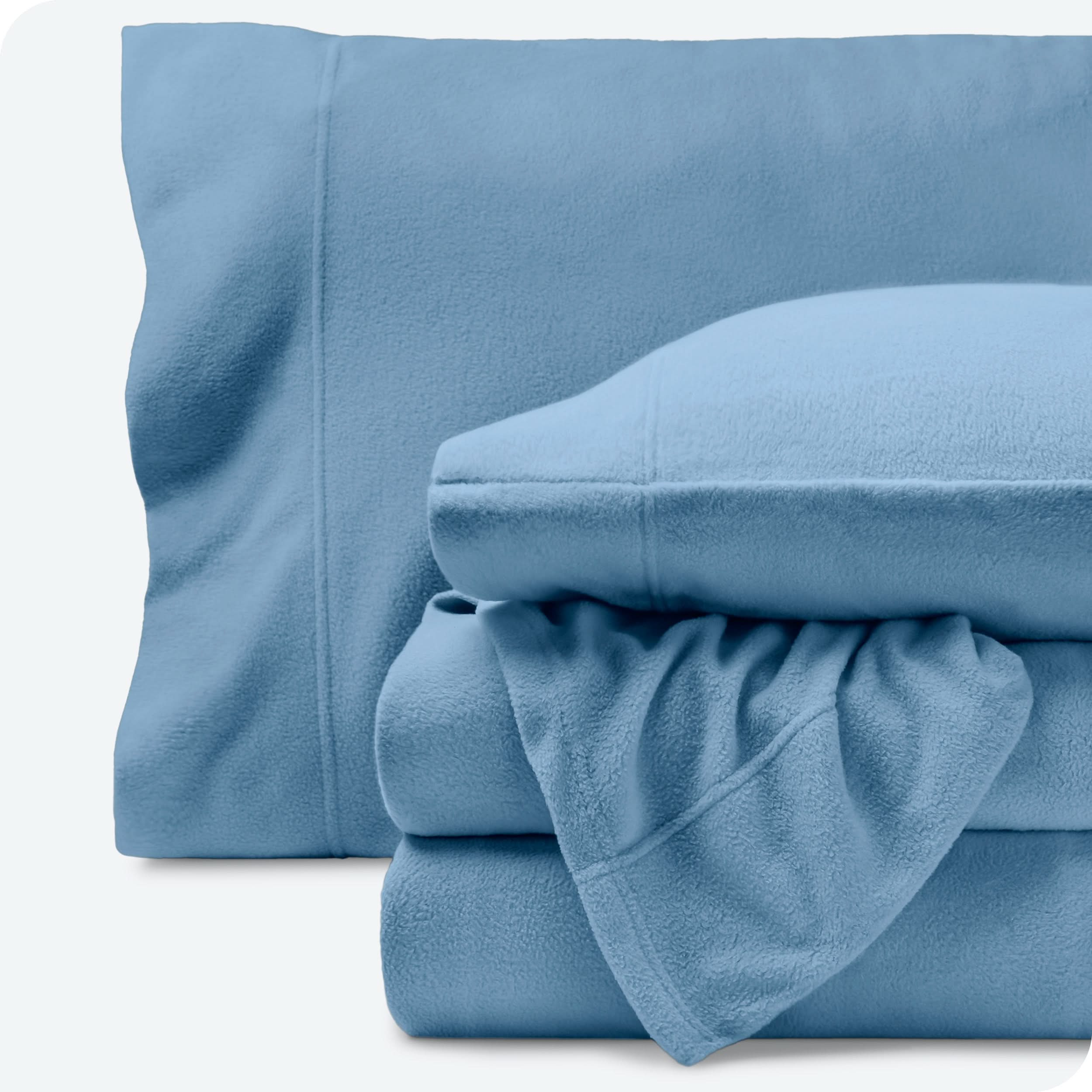 Fleece sheets folded neatly and stacked with pillows inside the pillowcases