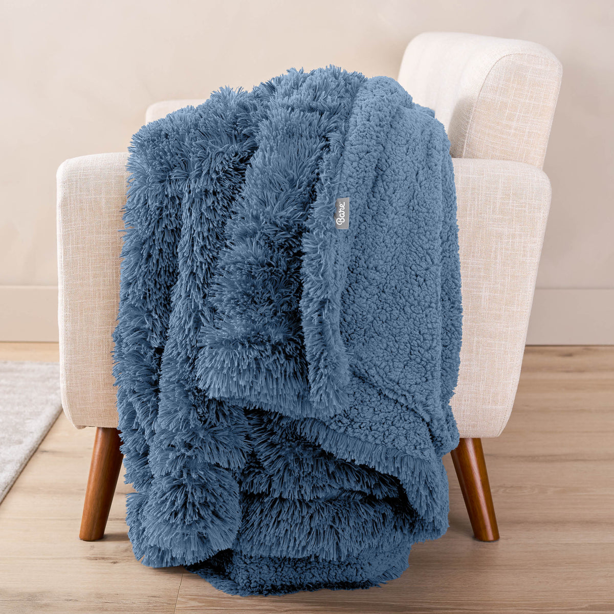 A shaggy blanket draped over the arm of a chair