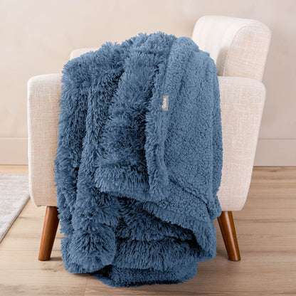 A shaggy blanket draped over the arm of a chair