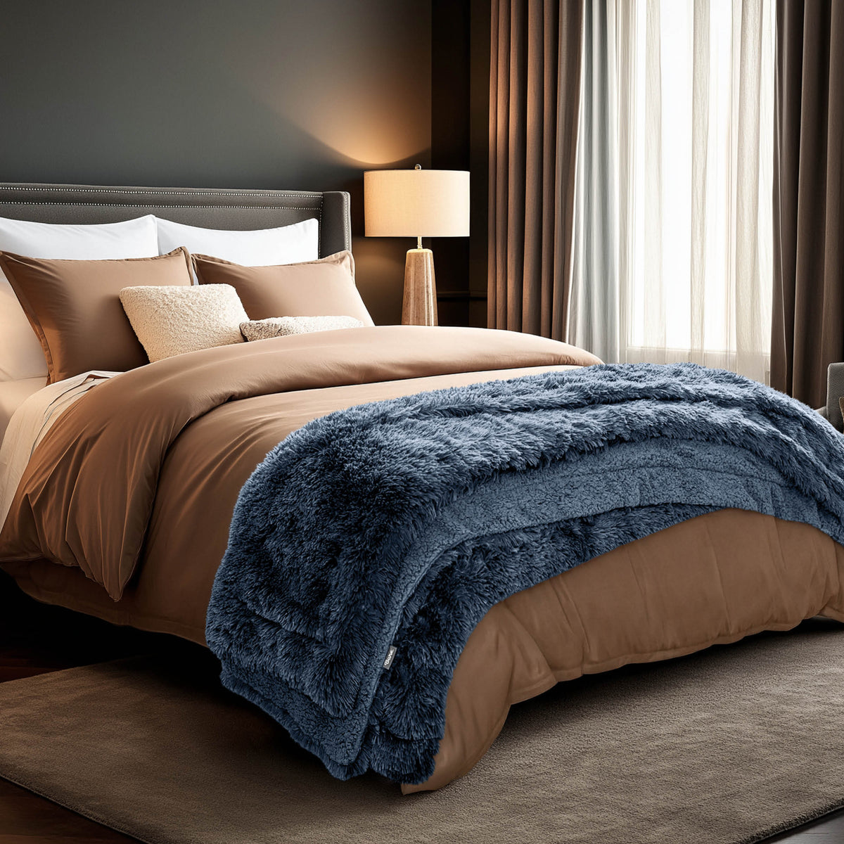 A shaggy faux fur blanket at the end of a bed