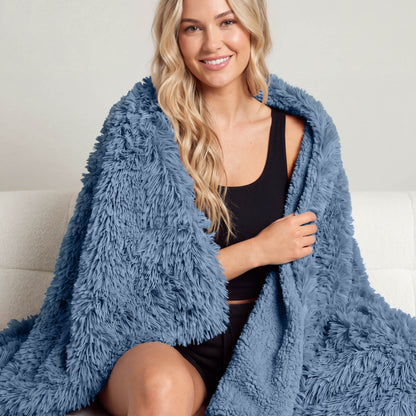 A woman sitting with a shaggy blanket wrapped around her