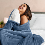 A woman smiling while wrapped in a sherpa blanket