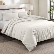 Flannel duvet cover set on a bed in a bedroom with a lamp and plant in the background.