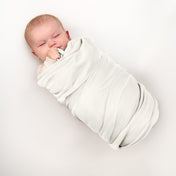 A baby wrapped in a flannel receiving blanket