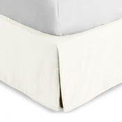 Bed skirt on a bed with white bedding