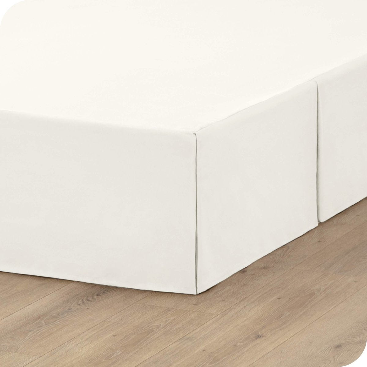 A box spring with a bed skirt on it