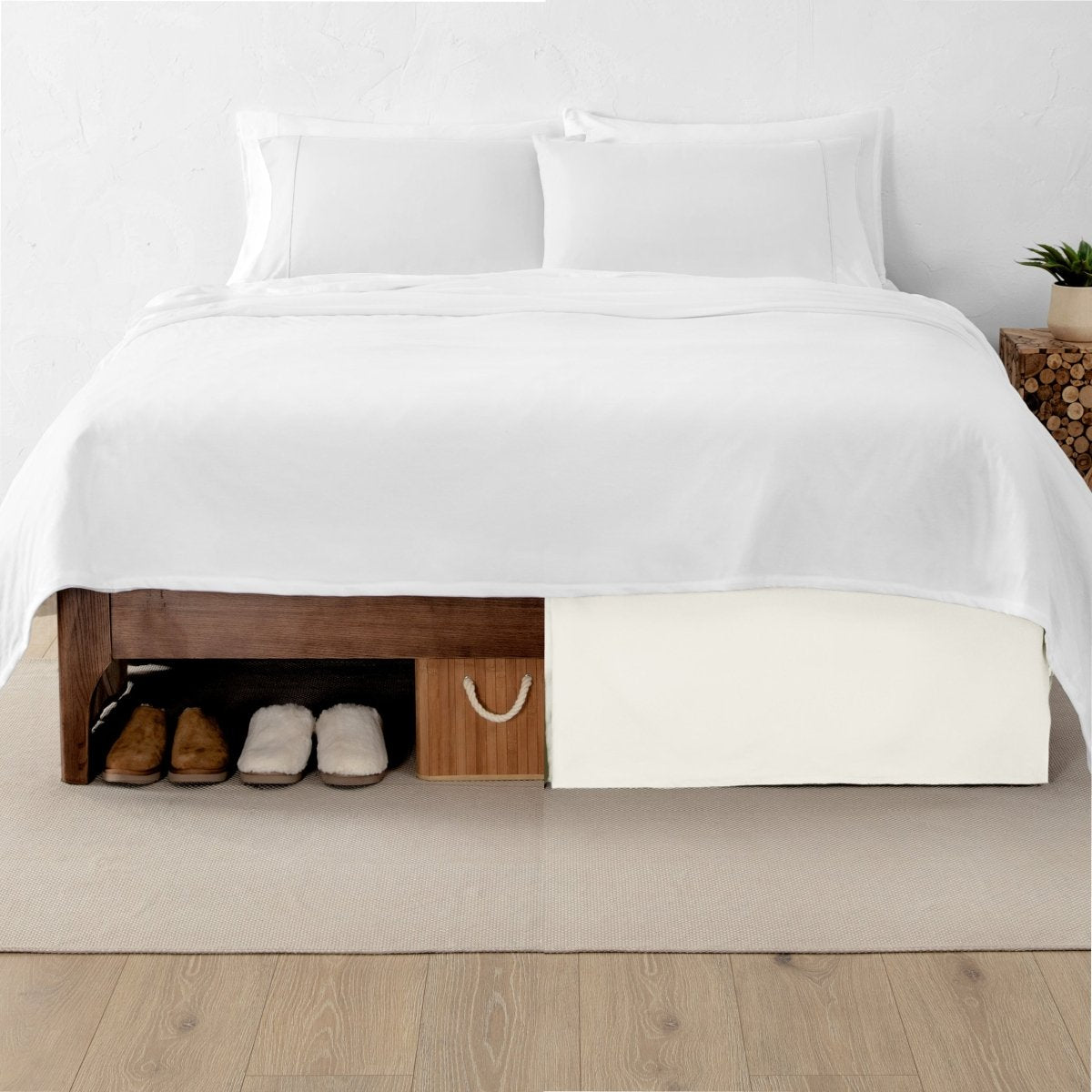 One side of a bed has shoes and a box under it while the other side has a bed skirt so that under the bed is hidden from view