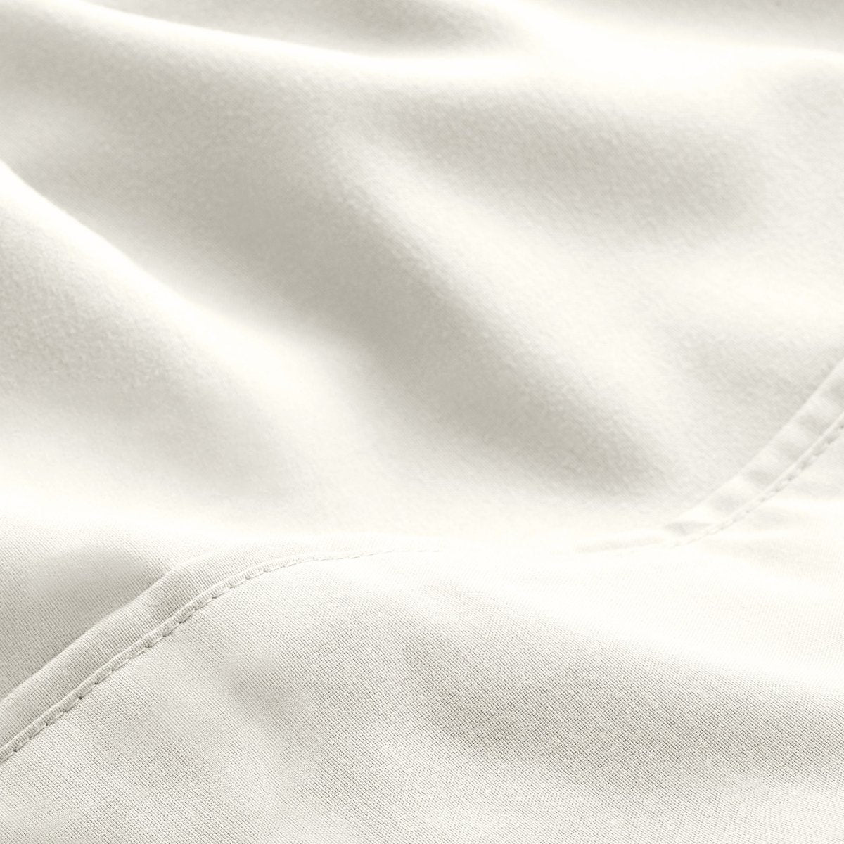 A close-up of microfiber fabric with soft folds and a visible stitched seam.