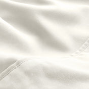 A close-up of microfiber fabric with soft folds and a visible stitched seam.