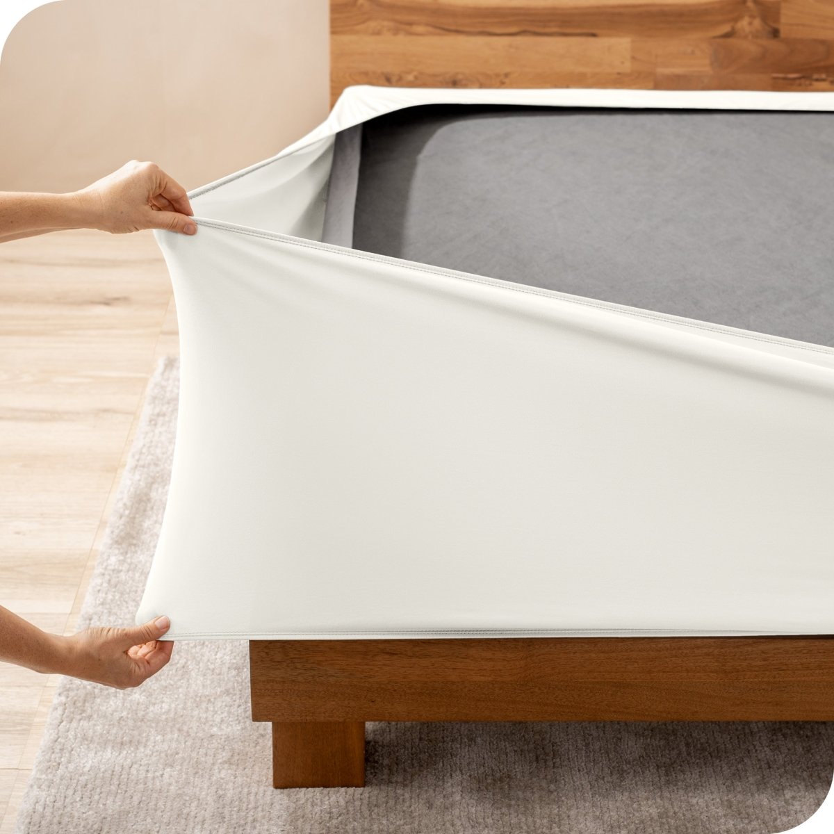 A person stretching a box spring cover