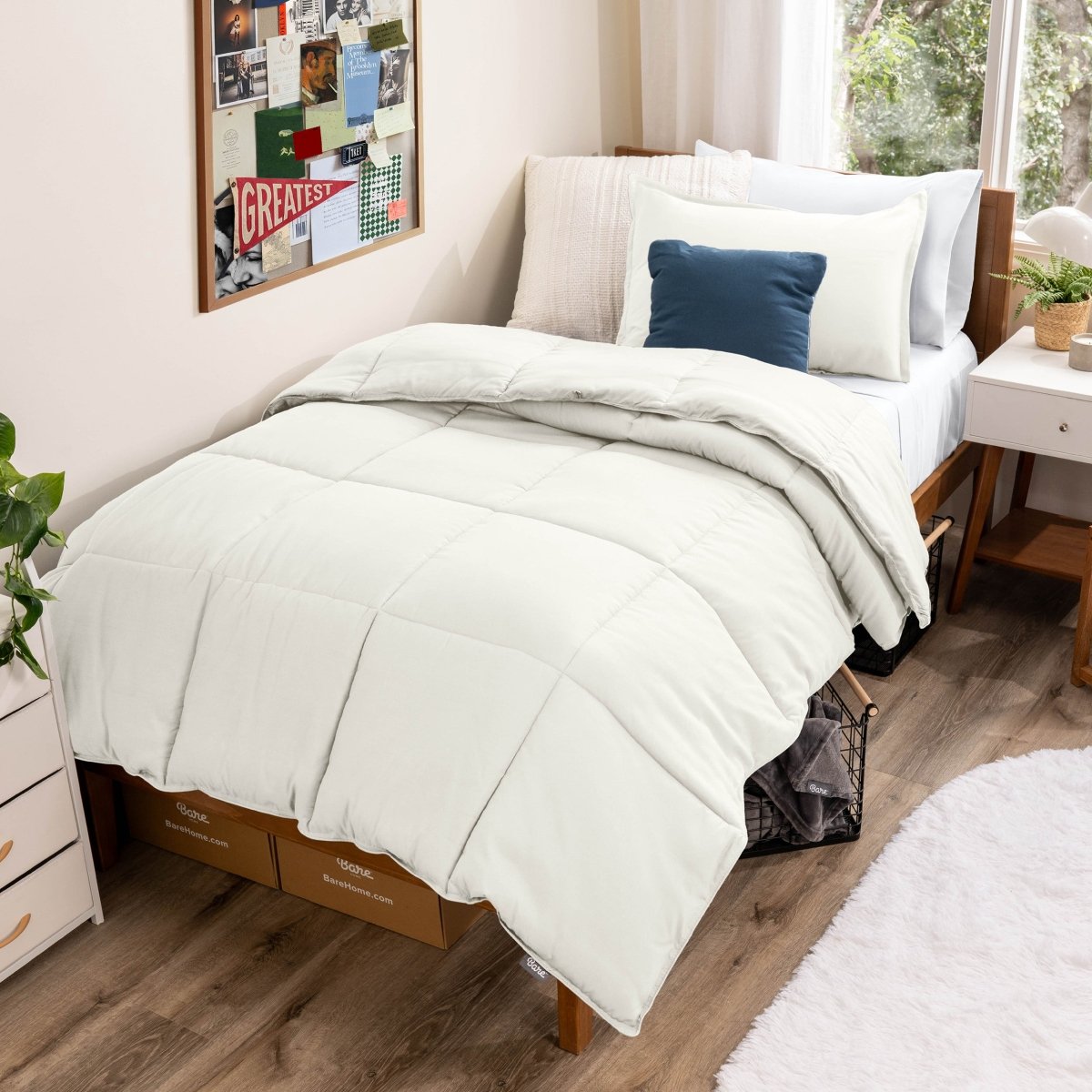 Comforter set on a bed in a bedroom with a window and decor.