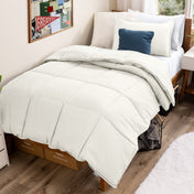Bed with comforter and pillows in a dorm room