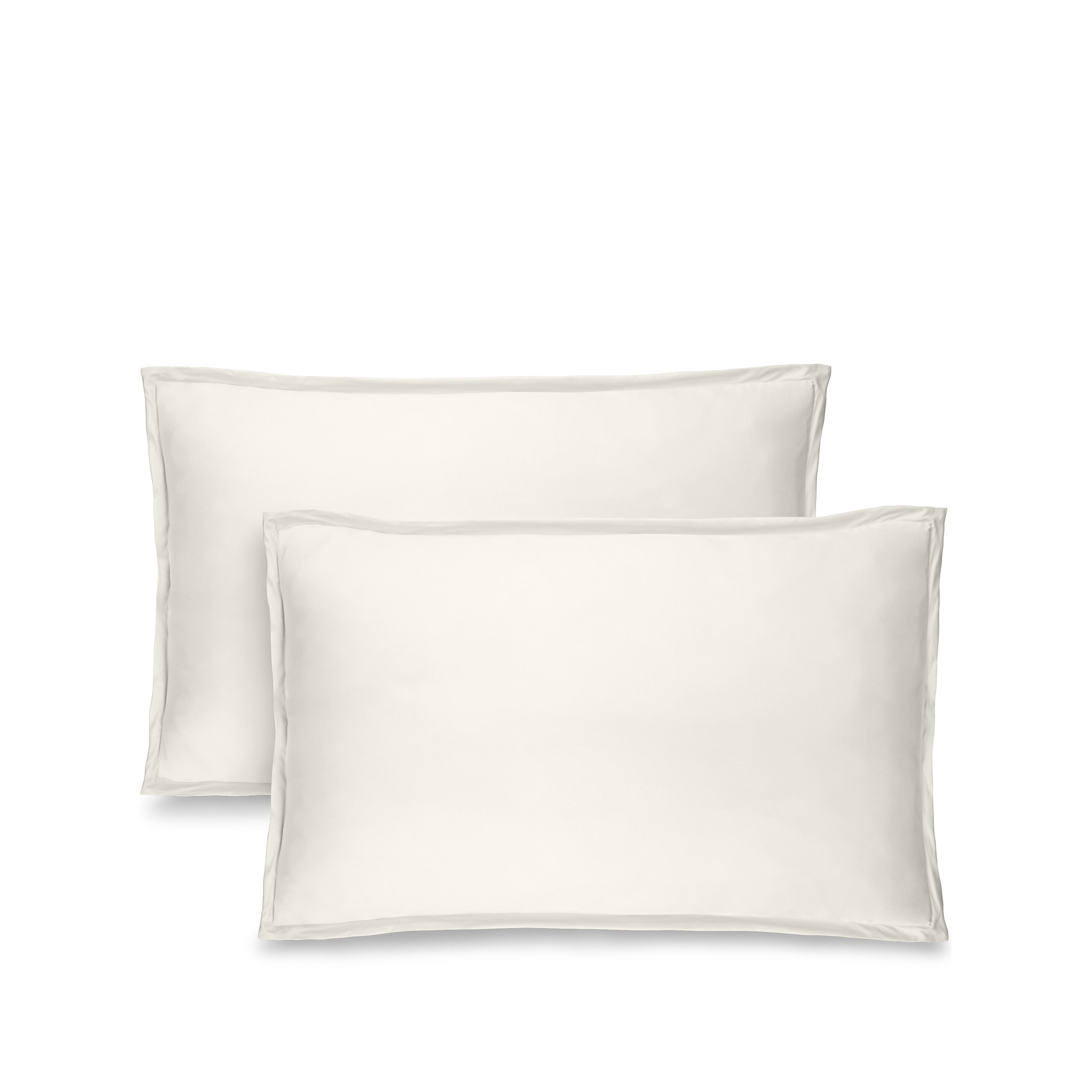 Two cream pillow shams on pillows standing up with one behind the other
