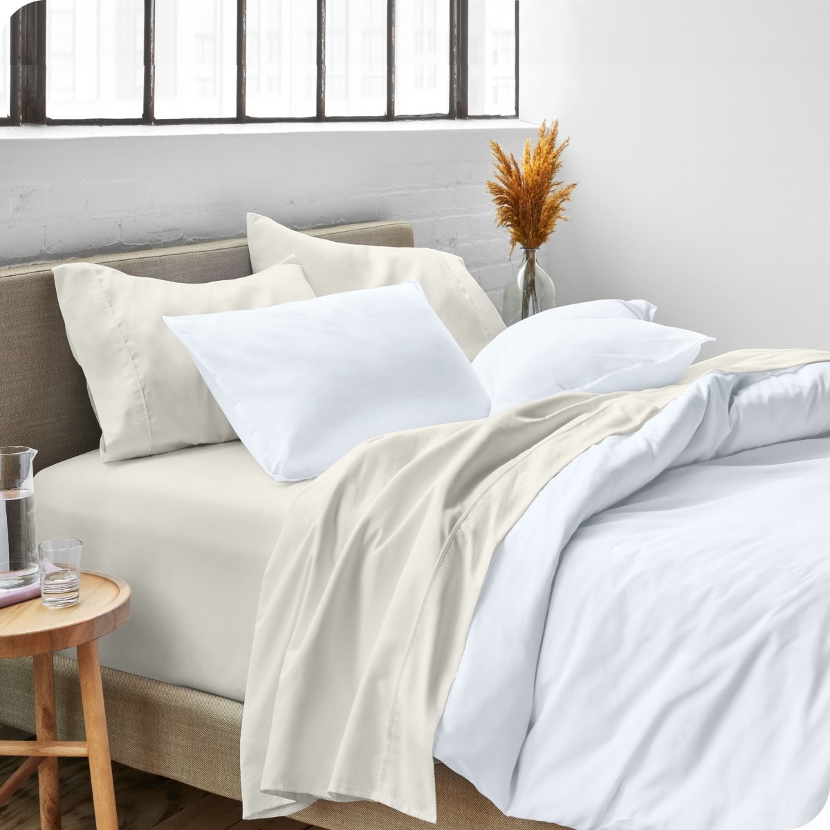 A side view of a bed made with microfiber sheets and a white duvet cover