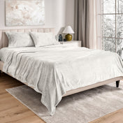 Neatly made bed in a well-lit bedroom.