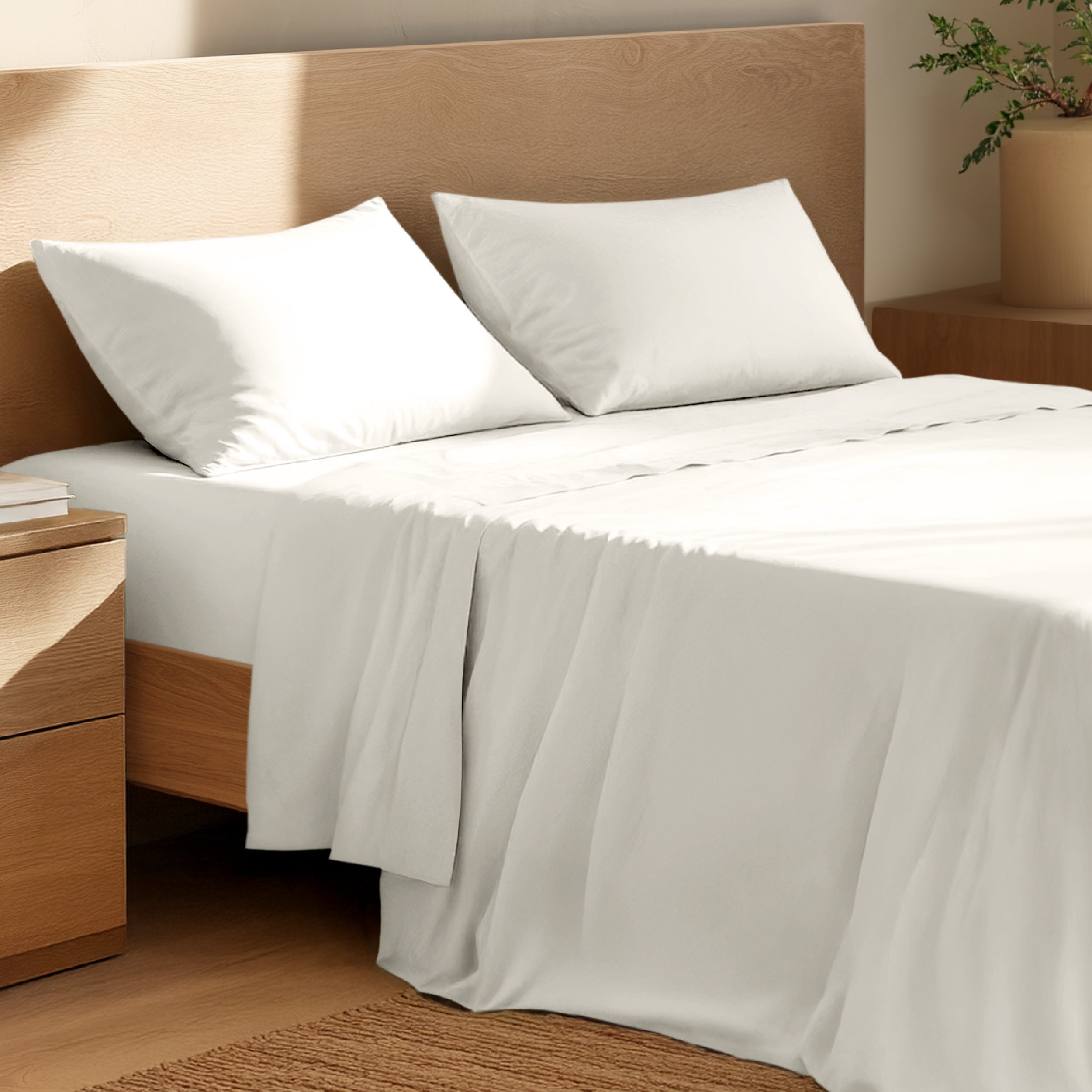 Bed with percale bedding and wooden headboard in a bedroom setting