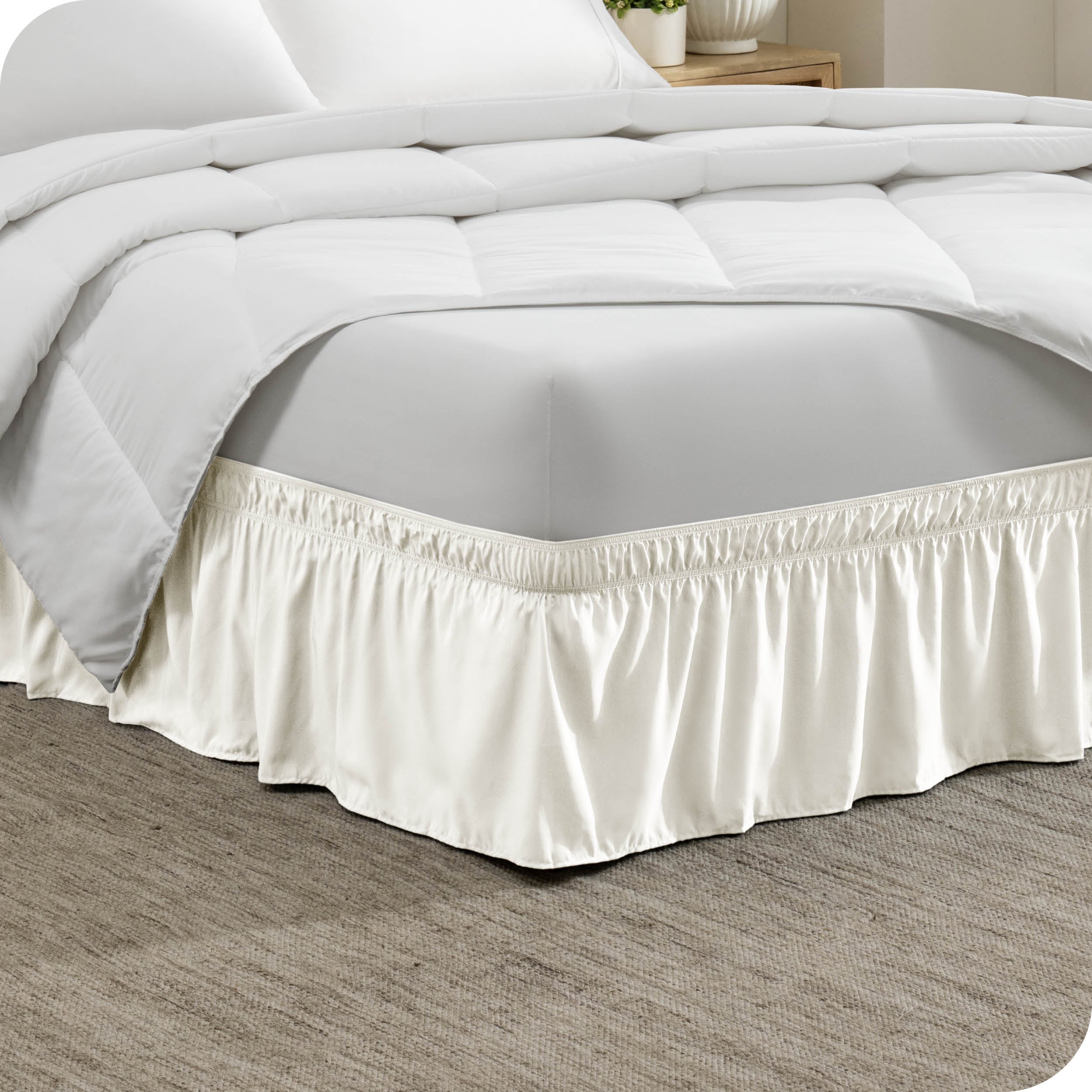 Corner of a bed with a polyester wrap around bed skirt on it