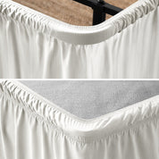 Close up of a polyester wrap around bed skirt on a bed frame and box spring