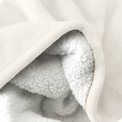 Close up of sherpa blanket showing texture of velvety soft side and sherpa backing