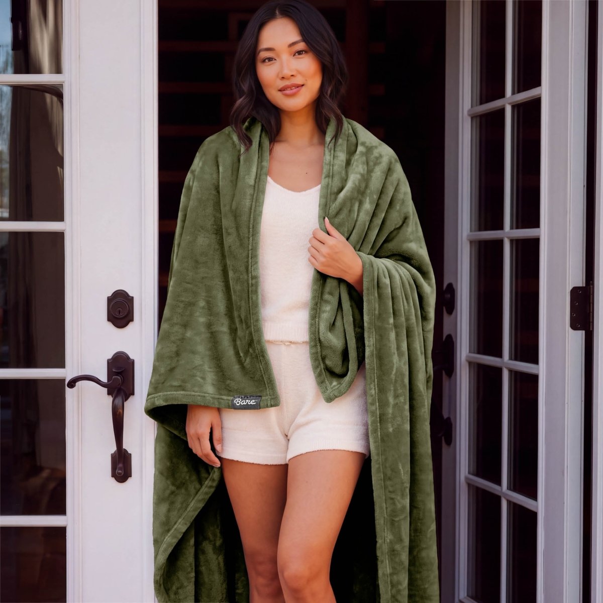 A woman standing with a microplush blanket wrapped around her
