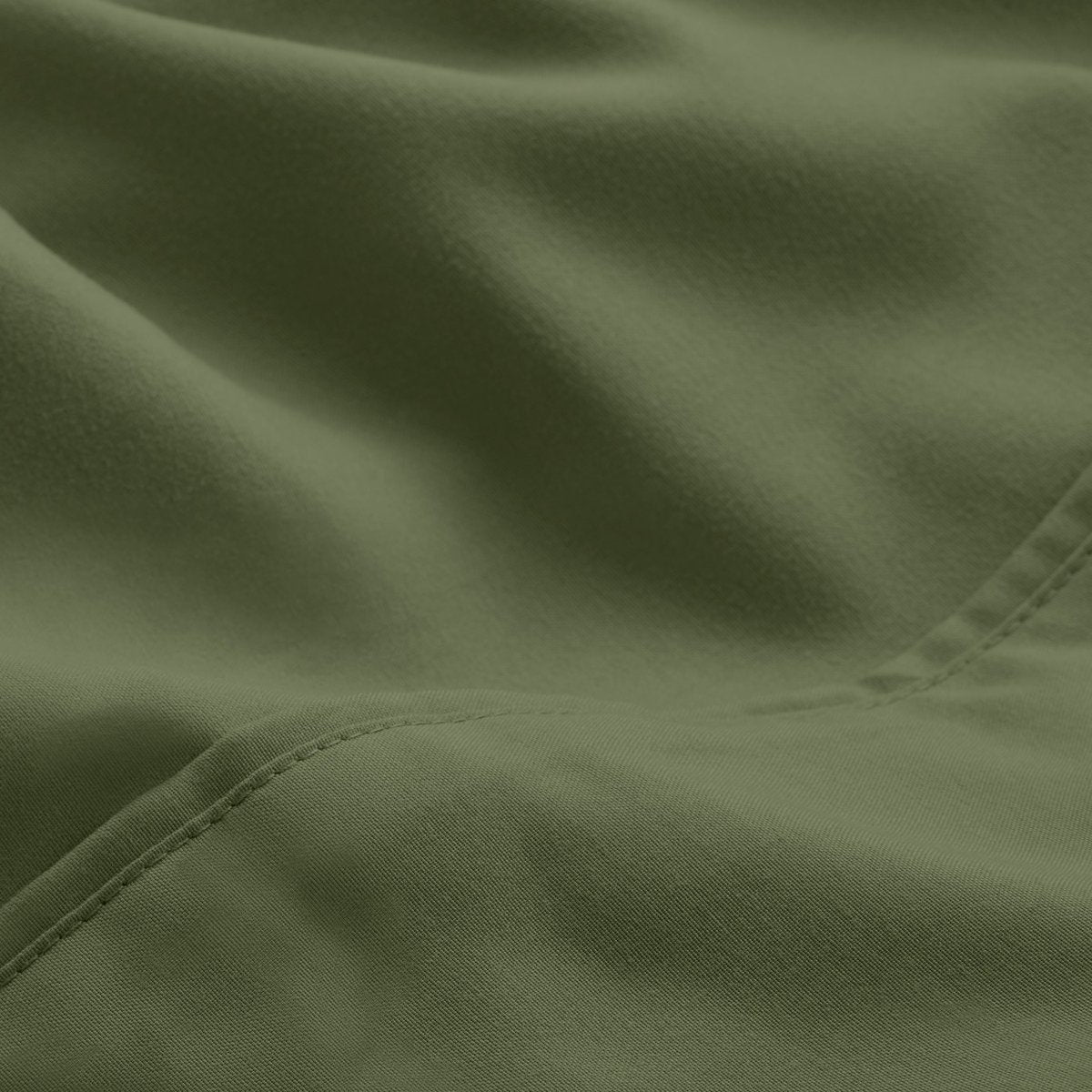 A close-up of microfiber fabric with soft folds and a visible stitched seam.