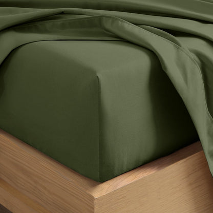 A close-up of a fitted sheet covering the corner of a bed frame, with matching top sheet draped over it.