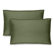 Two green pillow shams on pillows standing up with one behind the other