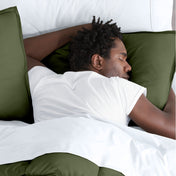 Man sleeping with his head resting on a pillow sham