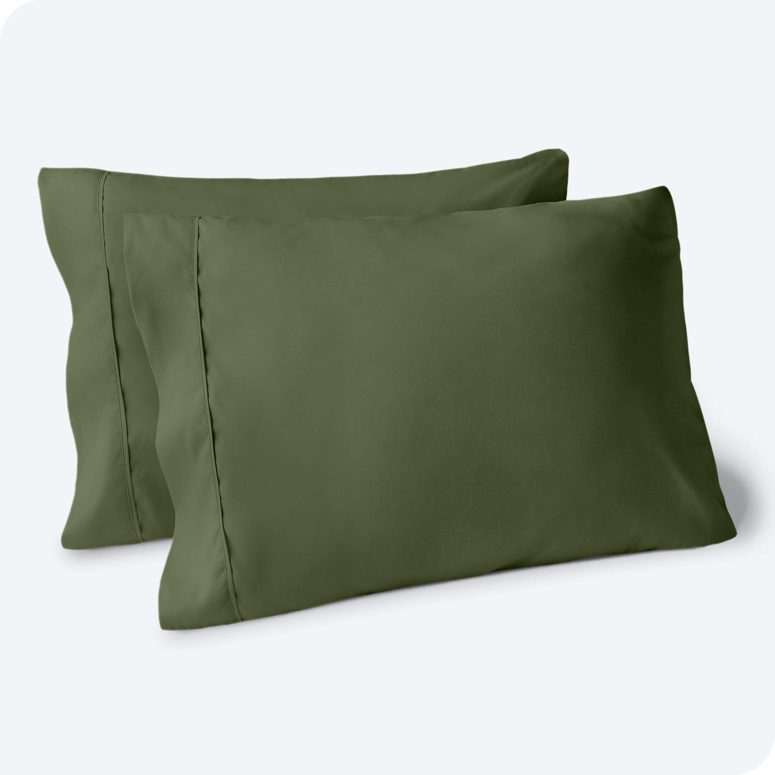 Two pillows on a white background with green pillowcases on them