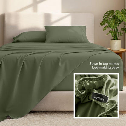 Bed sheets and pillows on a bed with a plant in the background