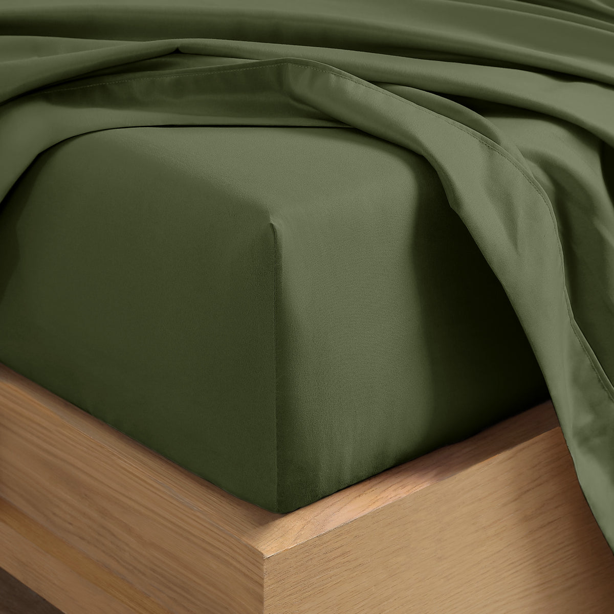 Close up of the corner of a mattress with a fitted sheet and flat sheet on it