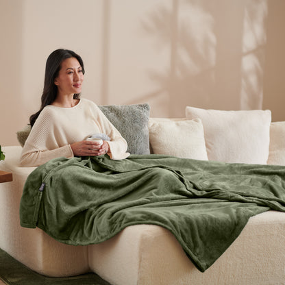 A woman sitting on a couch with a microplush blanket on her lap